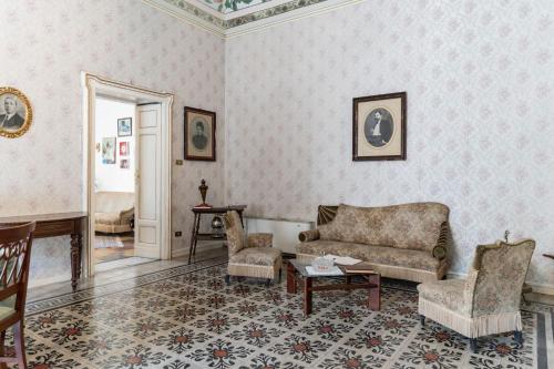 - un salon avec un canapé et des chaises dans l'établissement Palazzo Il Cavaliere B&B De Charme, à Modica