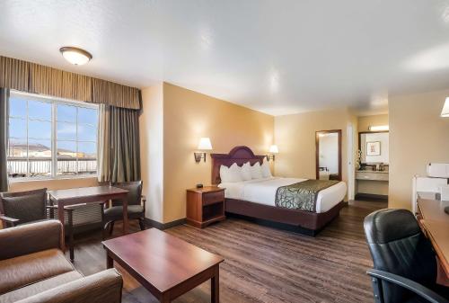 a hotel room with a bed and a living room at SureStay Hotel by Best Western Fernley in Fernley