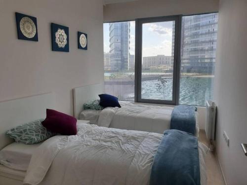 a bedroom with two beds and a large window at Amazing Apartment in a vibrant Area with Stunning Lake View in Istanbul! in Esenyurt
