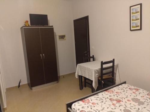 a room with a bedroom with a table and a cabinet at Xuxi Apartments in Lukovë