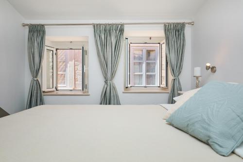 een slaapkamer met een bed en 2 ramen bij Room Annette in Dubrovnik
