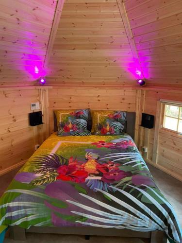 Ce lit se trouve dans une chambre en bois dotée de lumières violettes. dans l'établissement La Vallée De Taradeau, à Taradeau