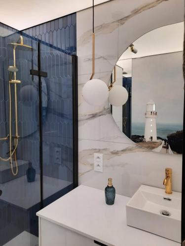 a bathroom with a white sink and a lighthouse at Nadmorski Bursztyn in Rowy