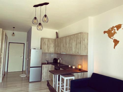 a kitchen with a refrigerator and a table in a room at RiverSea Apartment Saranda in Sarandë
