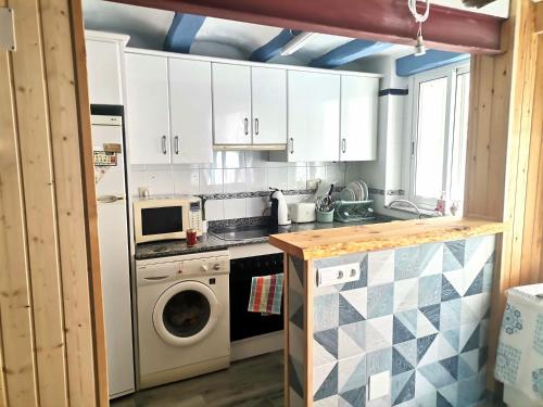 uma cozinha com armários brancos e uma máquina de lavar roupa em Mediterrani Haus em L'Ametlla de Mar