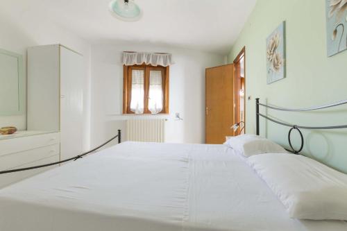 a white bedroom with a large bed with white sheets at Case al Tacco di Leuca in Marina di Leuca