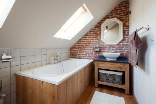 La salle de bains est pourvue d'une grande baignoire et d'un lavabo. dans l'établissement Vakantiewoning Tivoli, à Dilsen-Stokkem