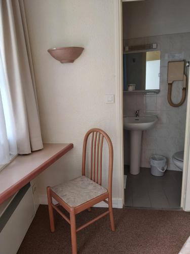 La petite salle de bains est pourvue d'une chaise et d'un lavabo. dans l'établissement Hotel Asteries, à Tours