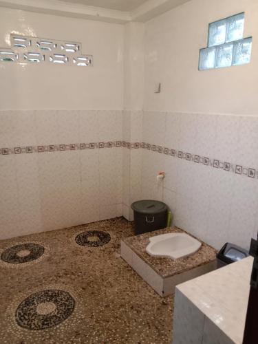 a bathroom with a toilet in the middle of a room at Enter Point in Bukit Lawang