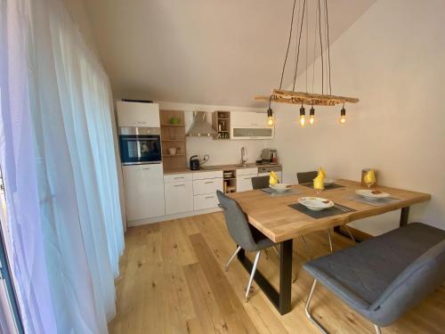 uma cozinha com uma mesa de madeira e cadeiras num quarto em Zirbenblick Apartment Turrach em Brandstätter