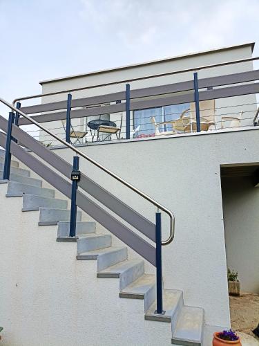 un escalier avec balustrade bleue à côté d'un bâtiment dans l'établissement Appartement de 2 chambres avec terrasse amenagee et wifi a Arnage, à Arnage