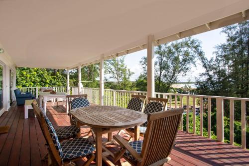 a wooden deck with a table and chairs on it at Casa Branca in Ponta do Ouro