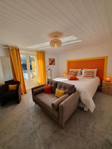 1 dormitorio grande con 1 cama y 1 sofá en Aux Lits du Canal, en Josselin
