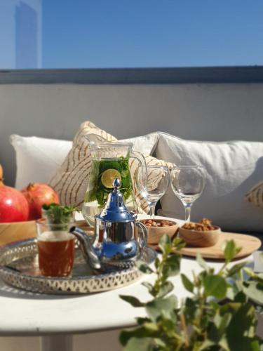 una mesa con tetera y vasos. en Dar Les Sirènes, en Essaouira