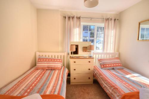 1 Schlafzimmer mit 2 Betten, einer Kommode und einem Fenster in der Unterkunft Seaview in Lyme Regis