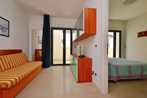 a living room with a couch and a bed at Residenza Verde in Lignano Sabbiadoro