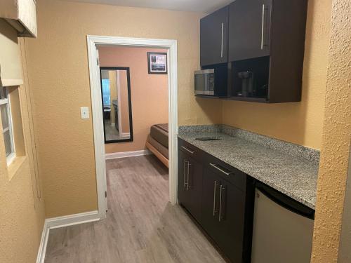 a kitchen with black cabinets and granite counter tops at Sunburst Hotel in Myrtle Beach