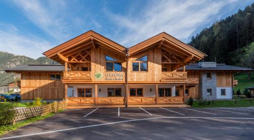 ein großes Gebäude mit Parkplatz in der Unterkunft Griena NaturChalets **** in Mayrhofen