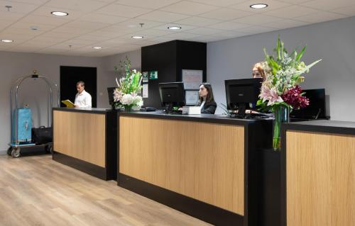 three people sitting at a counter in an office at Hotel Chamartin The One in Madrid