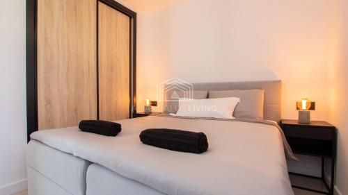 Un dormitorio con una cama blanca con dos bolsas negras.  en Contemporary loft style apartment with amazing sea views and with direct access to the beach from the community, en Málaga