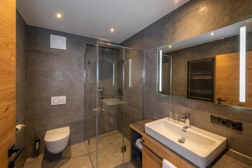 a bathroom with a sink and a shower and a toilet at Griena NaturChalets **** in Mayrhofen