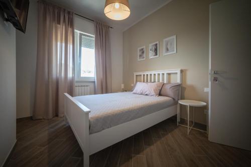 ein Schlafzimmer mit einem weißen Bett und einem Fenster in der Unterkunft Saint Joseph in Livorno