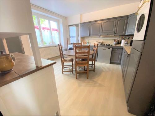 une cuisine avec une table, des chaises et un réfrigérateur dans l'établissement Appartement jardin, terrasse, parking privé, à 10 min de la plage, proche centre Bénodet - FR-1-481-114, à Bénodet