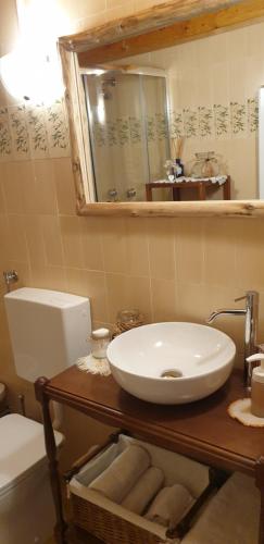 y baño con lavabo, aseo y espejo. en Casa all’antica fontana en Sùtrio