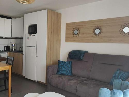 un salon avec un canapé et une cuisine dans l'établissement Appartement 2 pièces avec piscine, sports et fitness - Le Barcarès - FR-1-195-90, au Barcarès
