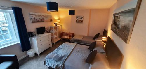 a small bedroom with a bed and a desk at The Bugle Inn in St Austell