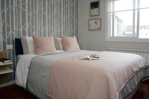 1 dormitorio con 1 cama blanca grande con almohadas rosas en Oliva Suite, en Pontevedra