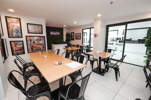 a restaurant with tables and chairs in a room at Rosey Hotel in Cabanatuan