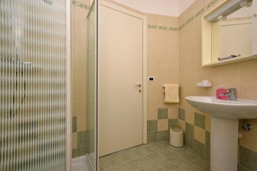 y baño con ducha y lavamanos. en Residenza Verde, en Lignano Sabbiadoro