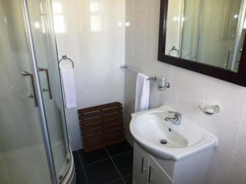 a white bathroom with a sink and a shower at Esplanade Hotel in Clacton-on-Sea