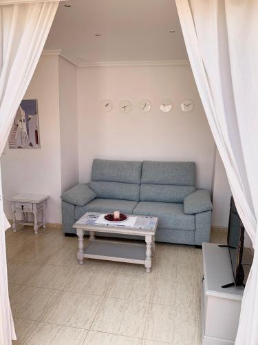 a living room with a blue couch and a coffee table at Torremar Natura Julia in Vera
