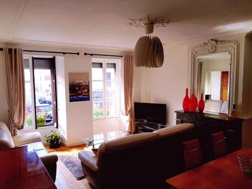 sala de estar con sofá y mesa en Appartement d'une chambre avec vue sur la ville et jardin a Langogne, en Langogne