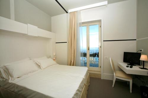 a bedroom with a bed and a desk and a window at Hotel Piccolo Portofino in Portofino