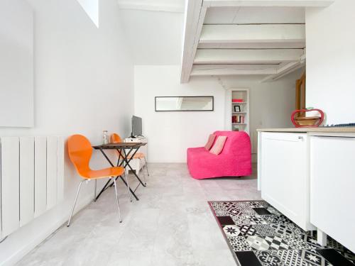um quarto com uma secretária e uma cadeira rosa em LE COCON D'AUTEUIL - ICI CONCIERGERIE em Auteuil