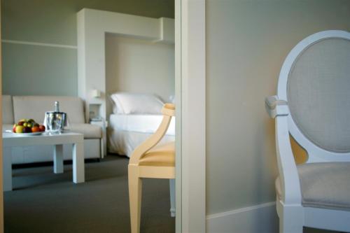 
a white chair sitting in a room next to a table at Hotel Piccolo Portofino in Portofino
