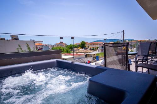 a hot tub on top of a building with water at Old Cinema Suites - Stylishly Decorated Retreat with Pool or Jacuzzi by the Sea in the Heart of Laganas Βy Villa Mana Gers in Laganas