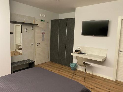 a bedroom with a bed and a desk and a television at LA META ROOMS in Potenza