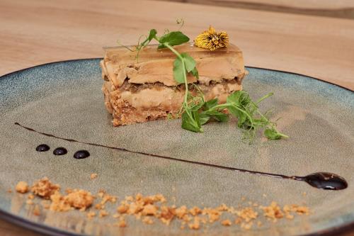 a piece of cake on a plate with a spoon at Hôtel du Beffroi Gravelines Dunkerque in Gravelines