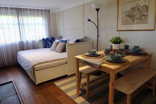 a small room with a bed and a table at Cozy and peaceful cabin 15 mins from Lyme Regis in Bridport