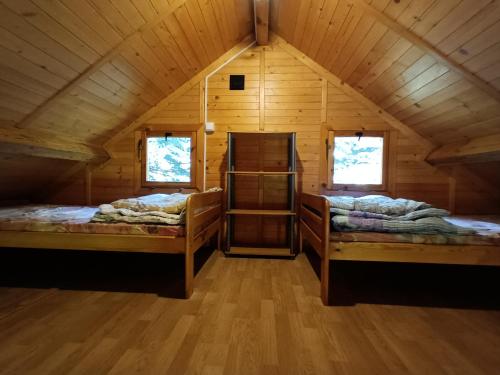 a room with two beds in a wooden cabin at Domki u Jacka in Władysławowo