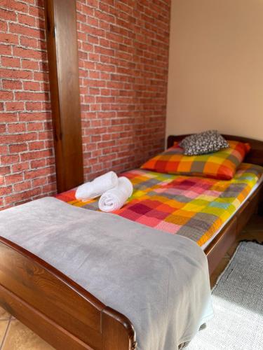 a bed in a room with a brick wall at Restauracja Rozmarzyn in Ostrzeszów