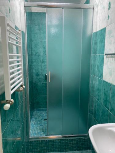 um chuveiro com uma porta de vidro na casa de banho em Ludmila guest house - гостевой дом "Людмила" em Odessa