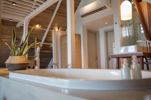 a bathroom with a sink and a mirror at Preskil Island Resort in Blue Bay