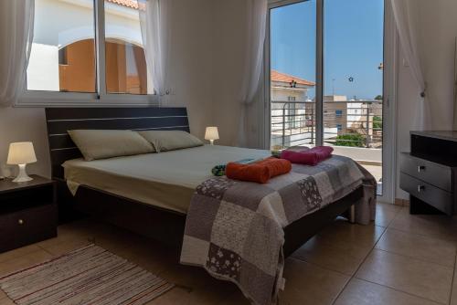 1 dormitorio con cama y ventana grande en Mythical Sands Resort & Spa, Evilion Apartment, en Paralimni