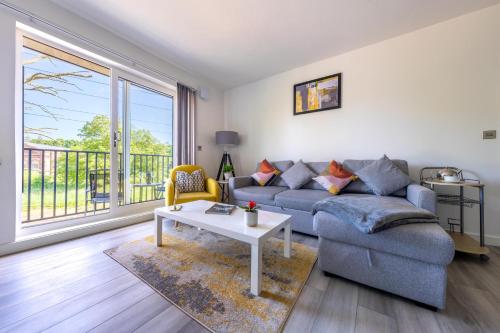a living room with a couch and a table at Ash View Place 3 -Heathrow - Thorpe Park - Free Parking in Staines
