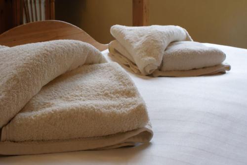 duas toalhas sentadas em cima de uma cama em Park House B&B em Leeds